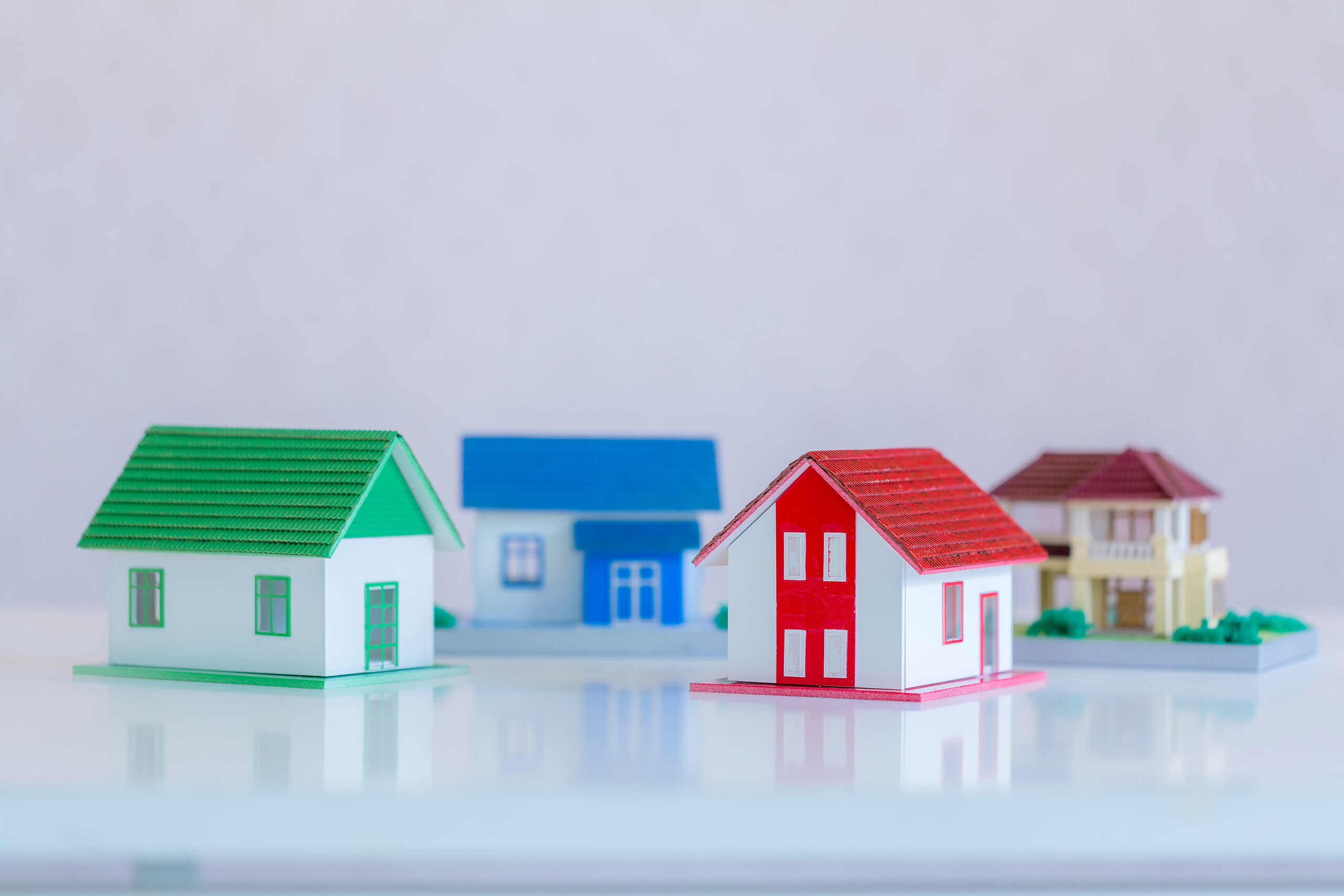 Model of house painted white under the tiled roof on the white background.