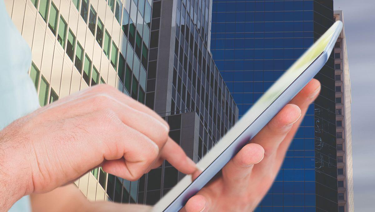 Composite image of hand man using digital tablet with city background