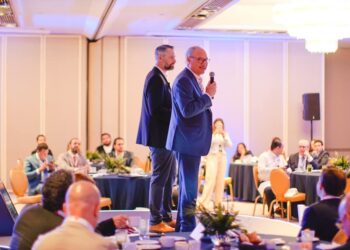 En el marco de un exclusivo evento organizado por Cushman & Wakefield, dos destacados profesionales del sector se posicionan en un elegante escenario. Uno de ellos, micrófono en mano, se dirige a una audiencia selecta compuesta por inversionistas y líderes del mercado inmobiliario premium, reunidos en un cómodo salón iluminado con calidez y dispuestos en mesas redondas. Este ambiente refleja la excelencia y distinción que caracteriza a los encuentros de alto nivel dedicados a las oportunidades más atractivas e innovadoras dentro del real estate de lujo.