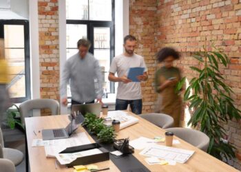 Un equipo de profesionales colabora en un exclusivo espacio de oficinas, diseñado con elegantes muros de ladrillo expuesto que reflejan la sofisticación y el vanguardismo del coworking premium en la Ciudad de México. La oficina ofrece amplios ventanales que inundan los ambientes con luz natural, integrando elementos modernos como pizarras blancas funcionales y detalles cuidadosamente seleccionados —incluyendo plantas ornamentales y una zona de café— para fomentar la productividad y el networking. Este entorno representa una oportunidad única para inversores o compradores que buscan espacios corporativos de alto nivel, ideales para empresas visionarias que valoran imagen, ubicación estratégica y un ambiente inspirador.