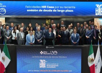 Un selecto grupo de líderes empresariales se reúne en el escenario principal de la Bolsa Mexicana de Valores para celebrar la exitosa colocación de deuda a largo plazo por parte de Hir Casa. La ocasión fue resaltada por mensajes institucionales que reconocieron este hito estratégico, proyectados en pantallas ubicadas sobre y debajo del grupo. Este logro refuerza la solidez financiera y la visión innovadora de Hir Casa dentro del segmento inmobiliario premium, destacando su capacidad para generar valor sostenible e impulsar oportunidades exclusivas para inversionistas y compradores exigentes.