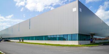 Ubicado en el dinámico sector industrial de México, se encuentra este imponente almacén premium de arquitectura contemporánea. La edificación destaca por su fachada de elegante revestimiento metálico gris y ventanas con cristal tintado en azul, proyectando una imagen sofisticada y moderna. Rodeado de vialidades pavimentadas y áreas verdes cuidadosamente diseñadas, este inmueble representa una oportunidad estratégica para inversionistas o compradores que buscan maximizar su portafolio en espacios industriales de alto nivel.