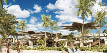 Dos personas se acercan a una exclusiva piscina rodeada de exuberante vegetación tropical, creando un entorno de privacidad y sofisticación absoluta. Al fondo, se alza un moderno edificio Muúk Karant cuya arquitectura vanguardista destaca por sus imponentes techos en forma de hoja, integrándose armónicamente con el paisaje natural. Bajo un cielo azul salpicado de nubes, esta propiedad representa una oportunidad incomparable para inversores y compradores que buscan excelencia estética, innovación arquitectónica y contacto directo con la naturaleza en el segmento inmobiliario premium.