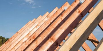 Vista detallada de las cerchas de madera bajo construcción, enmarcadas contra un cielo despejado. Las vigas—perfectamente alineadas y aseguradas con placas metálicas—evidencian prácticas constructivas sostenibles y duraderas. Esta meticulosa atención a la calidad estructural garantiza una inversión segura y atractiva para quienes buscan excelencia arquitectónica en el mercado inmobiliario premium.