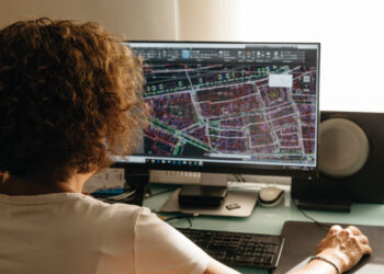 Un profesional altamente cualificado revisa minuciosamente planos técnicos de un desarrollo inmobiliario premium, utilizando software de arquitectura e ingeniería de vanguardia. En su análisis, evalúa rigurosamente los riesgos derivados de una posible ubicación inadecuada dentro del proyecto, asegurando la excelencia en cada detalle y la maximización del valor para inversores y compradores exigentes.