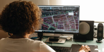 Un profesional altamente cualificado revisa minuciosamente planos técnicos de un desarrollo inmobiliario premium, utilizando software de arquitectura e ingeniería de vanguardia. En su análisis, evalúa rigurosamente los riesgos derivados de una posible ubicación inadecuada dentro del proyecto, asegurando la excelencia en cada detalle y la maximización del valor para inversores y compradores exigentes.