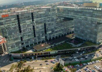 Vista aérea de un exclusivo complejo corporativo compuesto por edificios modernos de cristal y patio central, estratégicamente ubicado sobre una avenida principal con acceso inmediato a estacionamientos y servicios. Su diseño interconectado es resultado de 14 años de experiencia consolidada en el sector FIBRA en México, ofreciendo activos operativos que cumplen con los más altos estándares para inversionistas y compradores que buscan excelencia, rentabilidad y plusvalía en bienes raíces premium.