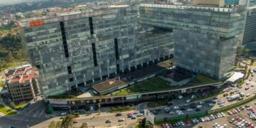 Vista aérea de un exclusivo complejo corporativo compuesto por edificios modernos de cristal y patio central, estratégicamente ubicado sobre una avenida principal con acceso inmediato a estacionamientos y servicios. Su diseño interconectado es resultado de 14 años de experiencia consolidada en el sector FIBRA en México, ofreciendo activos operativos que cumplen con los más altos estándares para inversionistas y compradores que buscan excelencia, rentabilidad y plusvalía en bienes raíces premium.