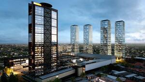 Un moderno horizonte urbano al anochecer destaca un imponente edificio corporativo con ventanas iluminadas en primer plano, acompañado de cuatro exclusivas torres residenciales de cristal al fondo. Esta imagen representa la solidez y sofisticación del mercado inmobiliario premium, respaldada por 14 años de experiencia consolidada en FIBRAs en México y una robusta cartera de activos operativos que garantizan rentabilidad, seguridad e innovación para inversionistas y compradores exigentes.