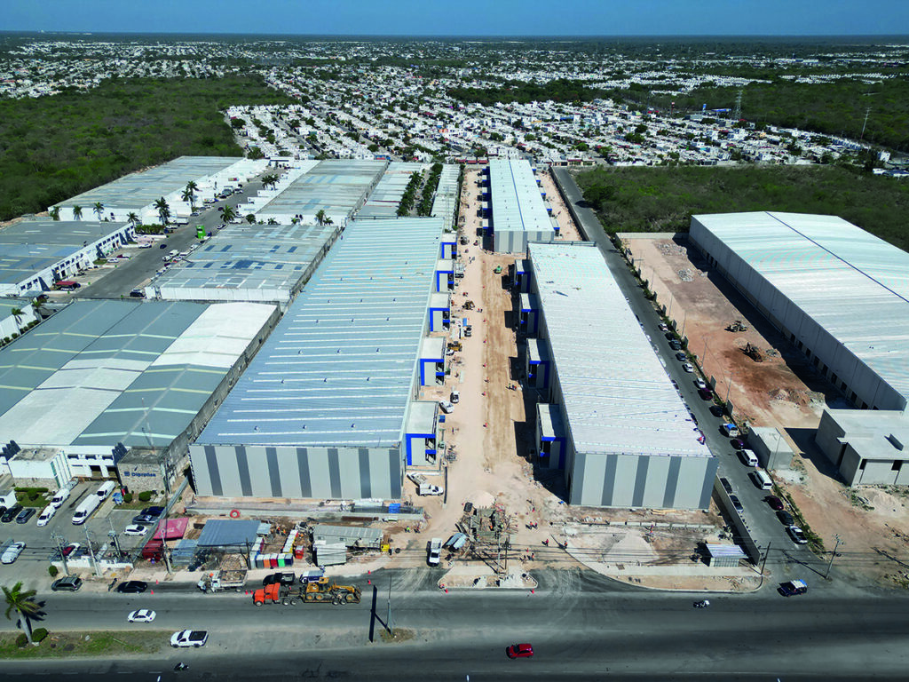 Vista aérea de un parque industrial en desarrollo en Mérida, conformado por amplias naves de última generación y equipamiento especializado, ideal para implementar soluciones logísticas Nexa Última Milla. El entorno cuenta además con bodegas adicionales y zonas residenciales consolidadas, lo que refuerza el potencial estratégico del proyecto. Una oportunidad única para inversionistas que buscan activos premium con alta proyección de crecimiento y una ubicación privilegiada dentro del corredor industrial más dinámico de la región.