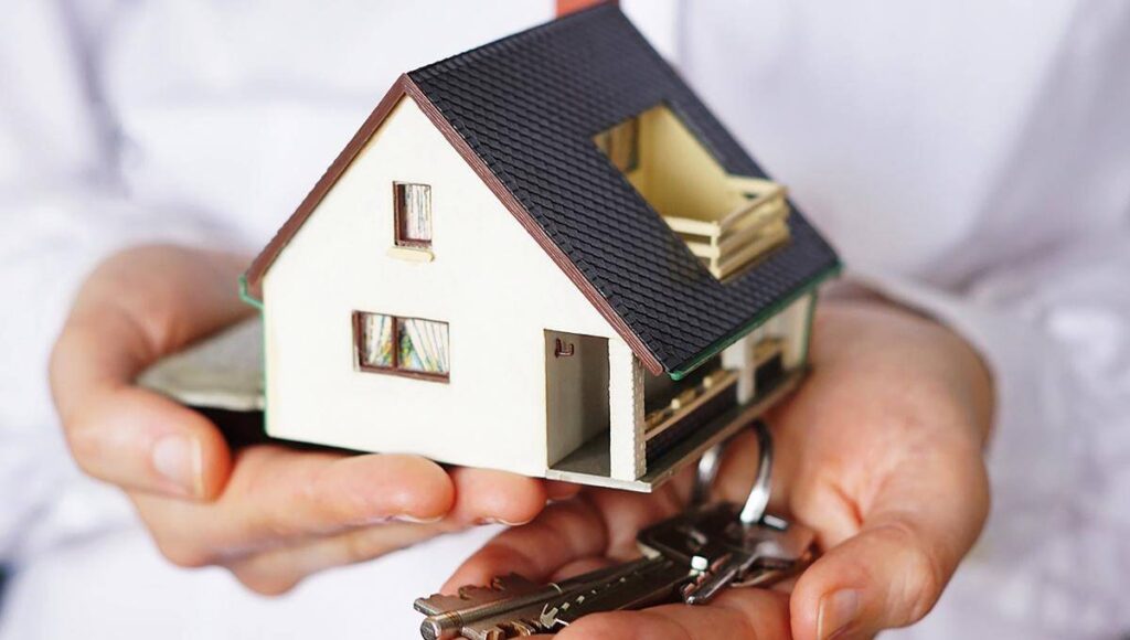 Un ejecutivo con camisa blanca sostiene una elegante maqueta de vivienda en una mano y, en la otra, un juego de llaves. Esta imagen simboliza la oportunidad de acceso a propiedades exclusivas en México, resaltando conceptos clave como patrimonio, inversión inteligente y adquisición inmobiliaria de alto nivel. Ideal para compradores exigentes e inversionistas que buscan calidad, seguridad y potencial de plusvalía en el sector premium del mercado residencial.