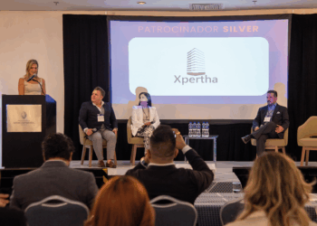 En el marco del exclusivo congreso REBS Puebla, cuatro destacados profesionales del sector inmobiliario se presentan en el escenario: uno de ellos lidera la conversación desde el podio, mientras los otros tres expertos acompañan la sesión como panelistas. En una pantalla principal se exhibe el logotipo de Xpertha junto a la distinción de "Patrocinador Silver", subrayando su compromiso con la excelencia y la innovación en bienes raíces premium. Ante una audiencia selecta y atenta, se exponen atractivas oportunidades de inversión diseñadas para satisfacer las expectativas de inversores visionarios y compradores exigentes en busca de proyectos inmobiliarios exclusivos y altamente rentables.