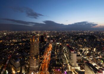 Vista aérea de la ciudad al anochecer, con edificios y avenidas iluminadas, destacando una torre central de gran altura. Esta imagen captura las alcaldías más exclusivas y cotizadas de la Ciudad de México, reconocidas por su alta demanda en el mercado premium de renta de departamentos. El cielo en transición suave subraya el dinamismo urbano y la sofisticación del entorno, atributos clave para inversionistas y compradores que buscan inmuebles excepcionales en las zonas más valoradas de CDMX.