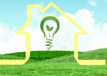 Una silueta dorada de una residencia se alza sobre suaves colinas verdes, bajo un cielo azul claro. En su interior, una luminaria verde con un brote simboliza el compromiso con la sustentabilidad en proyectos residenciales premium y comunidades planeadas. Esta representación visual destaca el enfoque en soluciones ecológicas y entornos exclusivos pensados para inversores y compradores que privilegian eficiencia energética, innovación arquitectónica y calidad de vida superior.